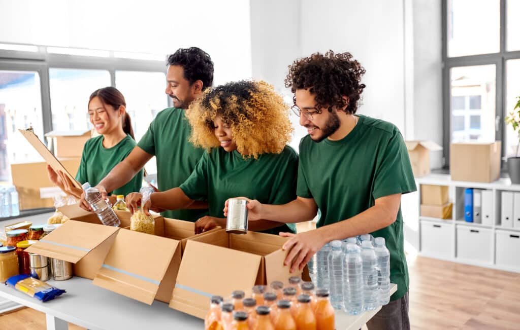 Volunteers packing a box of food donations